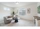 Sitting room area with two chairs, modern decor, large windows, and carpeted floors at 4408 Riviera Ct, Aurora, CO 80019