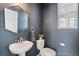 Stylish powder room features a vessel sink, hexagon mirror, and elegant blue textured wallpaper at 4408 Riviera Ct, Aurora, CO 80019