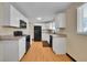 Modern kitchen with white cabinets and black appliances at 7505 Clay St, Westminster, CO 80030