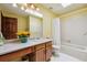 Bright bathroom with a skylight, yellow walls, and a white shower-tub combination at 1479 S Jasper St, Aurora, CO 80017
