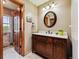 Charming bathroom featuring a wooden vanity with a white countertop and a round mirror at 1479 S Jasper St, Aurora, CO 80017