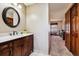 Elegant bathroom vanity with dark wood cabinetry, a white countertop, and a decorative round mirror at 1479 S Jasper St, Aurora, CO 80017