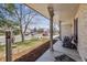Inviting front porch view with manicured lawn, charming chairs, and a tranquil neighborhood setting at 1479 S Jasper St, Aurora, CO 80017