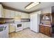 Bright kitchen with white appliances, countertops, tile floors, and ample cabinet space at 1479 S Jasper St, Aurora, CO 80017