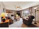 Cozy living room featuring brick fireplace, ceiling fan, plush furniture, and expansive window with backyard view at 1479 S Jasper St, Aurora, CO 80017