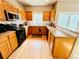 Kitchen area with stainless steel microwave and black appliances at 6188 Viewpoint Ave, Firestone, CO 80504