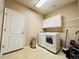 Laundry room with a washer, dryer, tile floor, and storage cabinets at 6188 Viewpoint Ave, Firestone, CO 80504