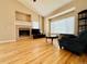 Bright living room featuring hardwood floors, fireplace, and large picture window at 6188 Viewpoint Ave, Firestone, CO 80504