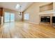 Bright and airy living room featuring hardwood floors, vaulted ceiling, and a cozy fireplace at 6188 Viewpoint Ave, Firestone, CO 80504