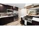 Modern kitchen with dark cabinets, stainless steel appliances, and island cooktop at 10601 W 78Th Ave, Arvada, CO 80005