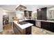 Modern kitchen with dark cabinets, stainless steel appliances, and a kitchen island at 10601 W 78Th Ave, Arvada, CO 80005