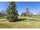 Picturesque park scene with walking paths, picnic tables, and mature trees under a blue sky at 10601 W 78Th Ave, Arvada, CO 80005