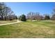 Tranquil park featuring a paved path, picnic benches, and an open grassy field with mature trees at 10601 W 78Th Ave, Arvada, CO 80005