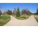 Scenic view of a park with a paved walking path, lush green grass, and various trees at 10601 W 78Th Ave, Arvada, CO 80005