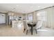 Open concept dining area with kitchen views and light wood floors at 1805 Papuan Ct, Brighton, CO 80601