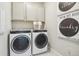 Laundry room with washer, dryer, cabinets and stylish wall art at 1805 Papuan Ct, Brighton, CO 80601