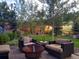 Charming backyard with a fire pit, patio furniture, and mature trees at 28665 Tepees Way, Evergreen, CO 80439