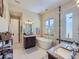 Bright bathroom with a modern soaking tub, glass-enclosed shower, and dual vanity sinks at 28665 Tepees Way, Evergreen, CO 80439