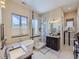 Bright bathroom with a soaking tub, glass shower, dual sinks, and modern fixtures at 28665 Tepees Way, Evergreen, CO 80439