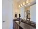 Modern bathroom featuring a single sink vanity with dark wood cabinets and a large mirror with bright lighting at 28665 Tepees Way, Evergreen, CO 80439