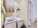 Bright laundry room with front loading washer and dryer, upper cabinets, and hanging rack at 28665 Tepees Way, Evergreen, CO 80439