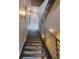 Striking stairway with modern, open metal railing and wooden treads, illuminated by stylish wall sconces at 28665 Tepees Way, Evergreen, CO 80439