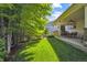 Backyard featuring a covered patio, lush green grass, and privacy landscaping at 11911 E Lake Cir, Greenwood Village, CO 80111