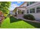 Backyard featuring a covered patio area, green lawn, and mature landscaping at 11911 E Lake Cir, Greenwood Village, CO 80111