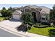 Charming home featuring a stone archway, lush landscaping, and a well-maintained front yard at 11911 E Lake Cir, Greenwood Village, CO 80111