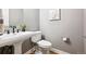 Stylish half bathroom featuring a pedestal sink, modern fixtures, and neutral decor at 11911 E Lake Cir, Greenwood Village, CO 80111