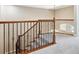 Carpeted staircase featuring a wooden banister with decorative iron spindles and a window on the landing at 11911 E Lake Cir, Greenwood Village, CO 80111