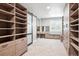 Bright walk-in closet with built-in shelving and sliding door with mirrors for full dressing area at 11911 E Lake Cir, Greenwood Village, CO 80111