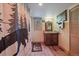 Well-lit bathroom with wood-look flooring, vanity, and a shower with a decorative curtain at 3065 Piney Ridge Rd, Evergreen, CO 80439