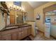 Well-lit bathroom featuring double sinks, granite countertops, and tiled shower at 3065 Piney Ridge Rd, Evergreen, CO 80439