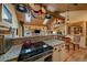 Open-concept kitchen with stainless steel appliances, granite countertops, and wood beam ceilings at 3065 Piney Ridge Rd, Evergreen, CO 80439