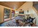 Comfortable living room with a leather sofa, a unique tree-trunk table and forest themed rug at 3065 Piney Ridge Rd, Evergreen, CO 80439