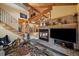 Living room with a stone fireplace, vaulted ceiling, a forest rug, and a staircase at 3065 Piney Ridge Rd, Evergreen, CO 80439