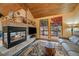 Inviting living room with a cozy fireplace, a bear themed rug, and sliding glass doors at 3065 Piney Ridge Rd, Evergreen, CO 80439