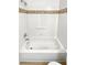 Bathroom showing a bathtub with decorative tile, grab bar, and shower head at 1256 S Zeno Cir # E, Aurora, CO 80017