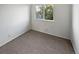 Bright bedroom with neutral carpet, white walls, and a window providing natural light at 1256 S Zeno Cir # E, Aurora, CO 80017