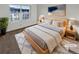 Bright bedroom with a wooden bed frame, white linens, bedside tables, and a large window offering natural light at 1256 S Zeno Cir # E, Aurora, CO 80017