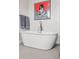 Modern bathroom features a freestanding tub, stylish art and a luxury faucet at 1373 S Garfield St, Denver, CO 80210