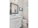 Powder room featuring modern vanity with quartz counters, updated fixtures, and decorative mirror at 1373 S Garfield St, Denver, CO 80210