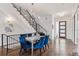 Elegant dining area featuring hardwood floors, a modern chandelier, and stylish blue chairs at 1373 S Garfield St, Denver, CO 80210