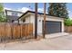 Rear view showing a garage and access to the main house via a wooden gate in a fenced yard at 1373 S Garfield St, Denver, CO 80210