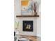 Close-up of a modern fireplace featuring white tile surround and a wooden mantel at 1373 S Garfield St, Denver, CO 80210