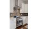 The chef's kitchen has white cabinets, stainless appliances, stylish subway tile and modern fixtures at 1373 S Garfield St, Denver, CO 80210