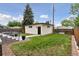 Backyard featuring a modern outbuilding with vertical siding and a well-manicured lawn at 1373 S Garfield St, Denver, CO 80210
