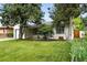A charming single-story home featuring a well-maintained lawn and mature trees, enhancing its curb appeal at 1924 Yosemite St, Denver, CO 80220