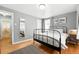 Spacious main bedroom with hardwood floors, two windows, and a decorative mirror at 1924 Yosemite St, Denver, CO 80220